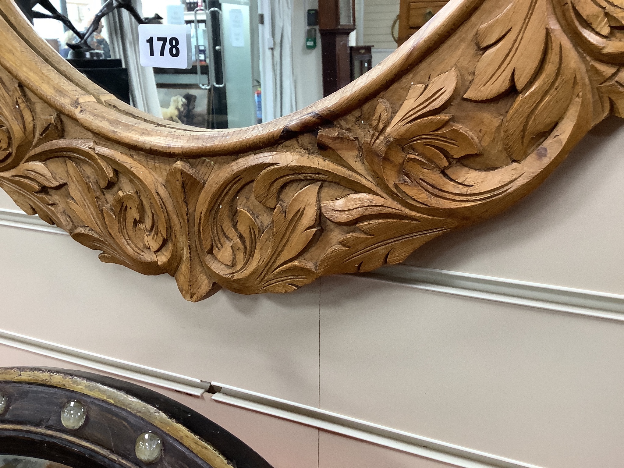 A carved oak oval framed wall mirror, width 70cm, height 109cm